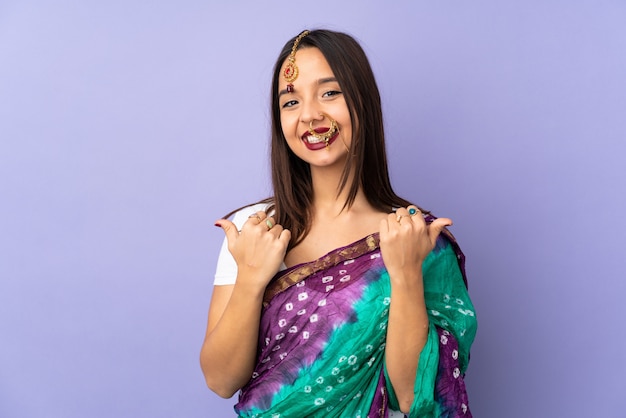 ジェスチャー親指と笑顔で紫色の背景に分離された若いインド人女性 プレミアム写真
