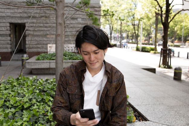 Young japanese man spending time outdoors alone Free Photo