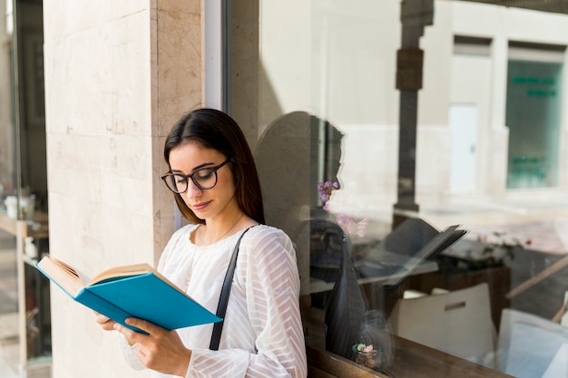 Free Photo | Young lady holding book near window