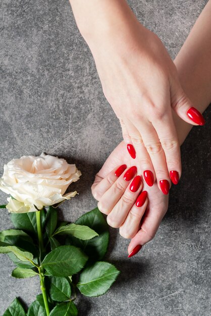 Young lady is showing her red manicure nails | Premium Photo