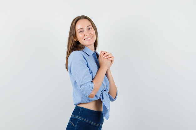 Free Photo Young Lady Keeping Clasped Hands On Chest In Blue Shirt 