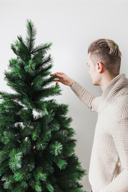 Free Photo | Young man decorating christmas tree