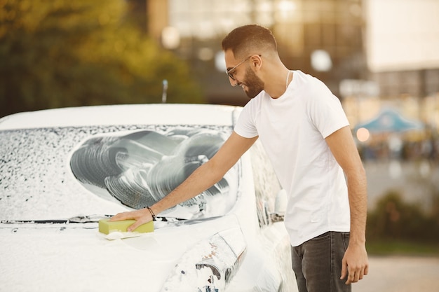 Free Photo | Young man in fashion clothes washing car at car wash ...