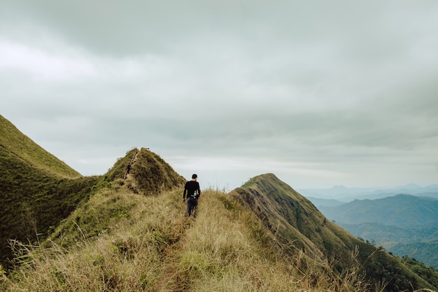 Premium Photo | Young man hiking he was walking along the ridge to ...