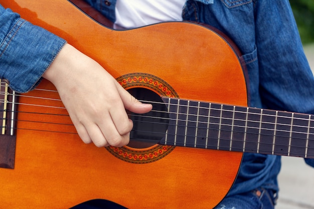 若い男がギターを弾き 音楽を演奏します プレミアム写真