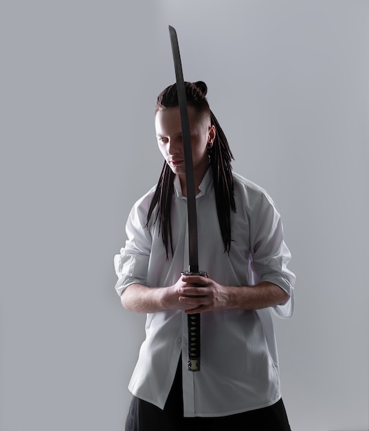 Premium Photo | Young man holding a samurai sword.