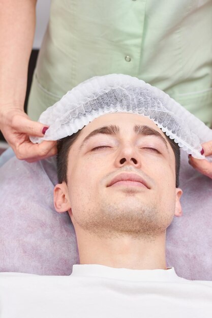 premium-photo-young-man-in-the-hospital-doctor-putting-hat-on-patient