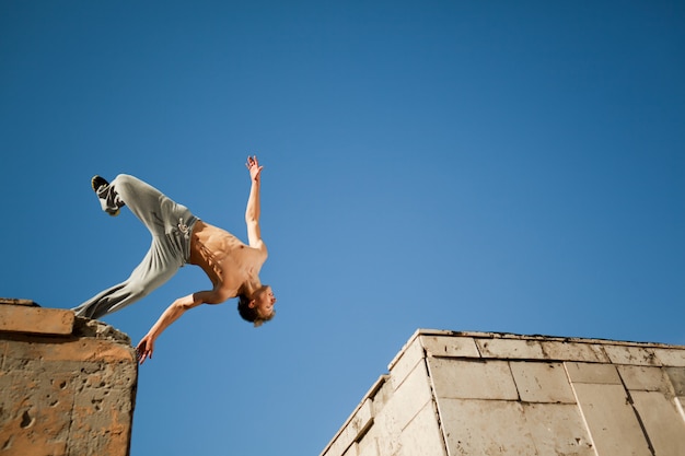 Premium Photo Young Man Jumping And Practicing Parkour Between Two