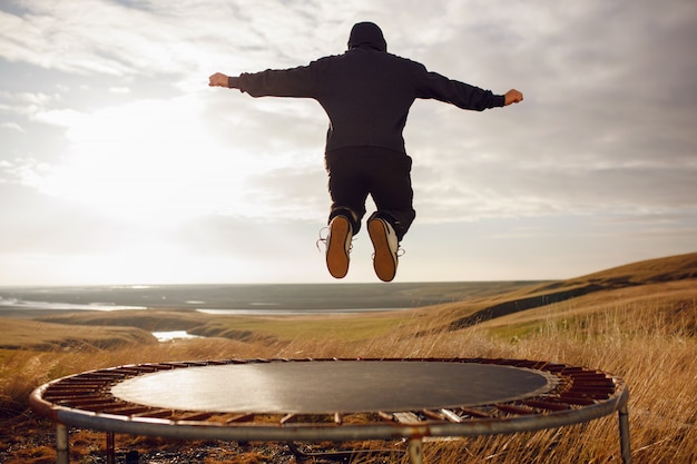 Premium Photo | Young man jumping on a trampoline