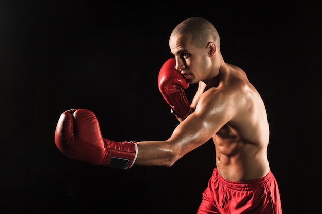 Free Photo | The young man kickboxing on black