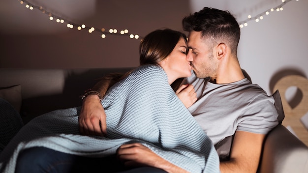 Free Photo | Young man kissing with woman lying on sofa