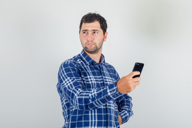 Free Photo | Young Man Looking Away With Smartphone In His Hand In ...