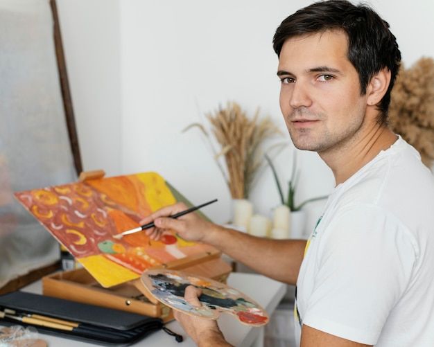 Free Photo | Young man painting with acrylics