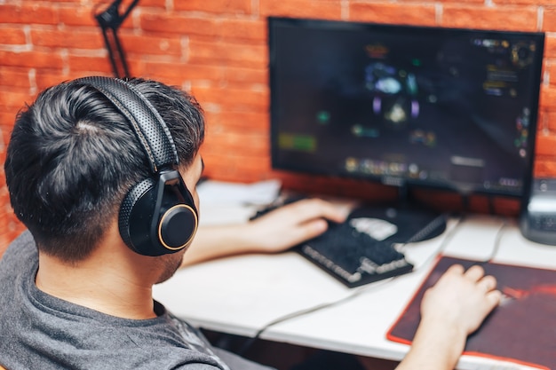 Young man playing game on computer, banner Premium Photo