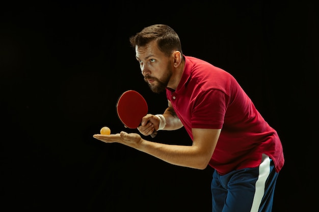 Young man playing table tennis on black studio Free Photo