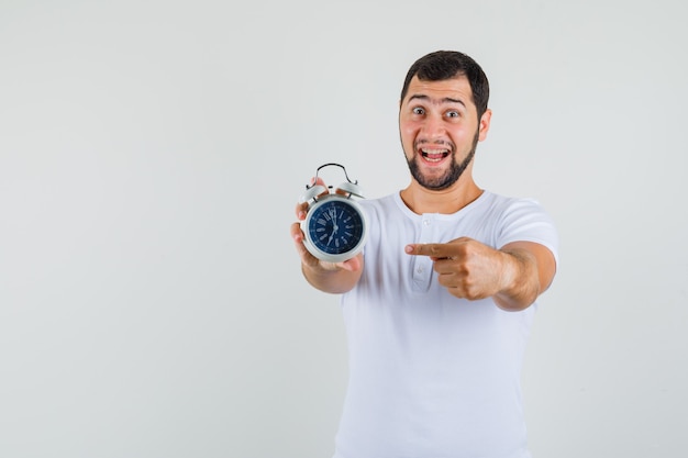 Free Photo | Young man pointing at clock in white t-shirt and looking ...