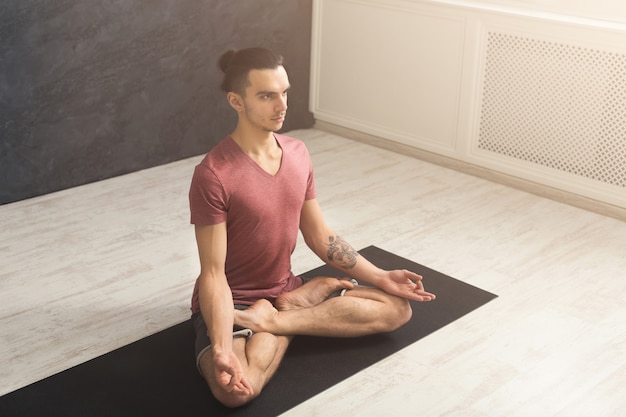 Premium Photo | Young man practicing yoga, meditation exercises. guy ...