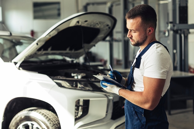 Premium Photo | Young man at service repairing car