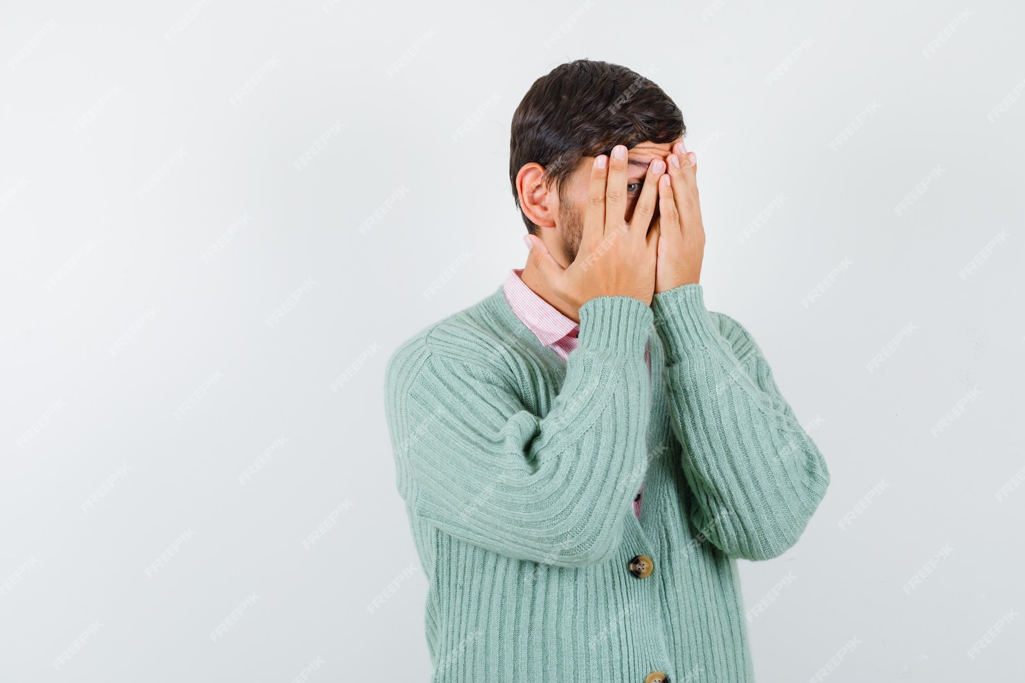 Free Photo | Young man in shirt, cardigan looking through fingers and ...