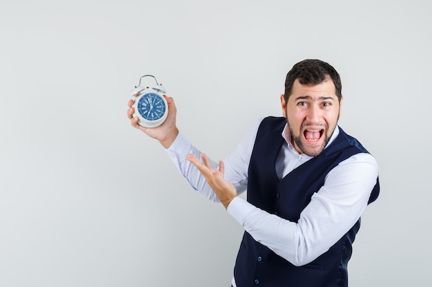 Free Photo | Young man shouting while pointing at alarm clock in shirt ...