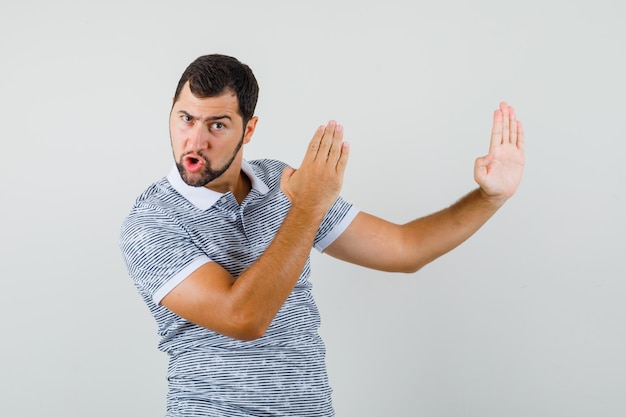 Free Photo | Young man showing karate chop gesture in t-shirt and ...