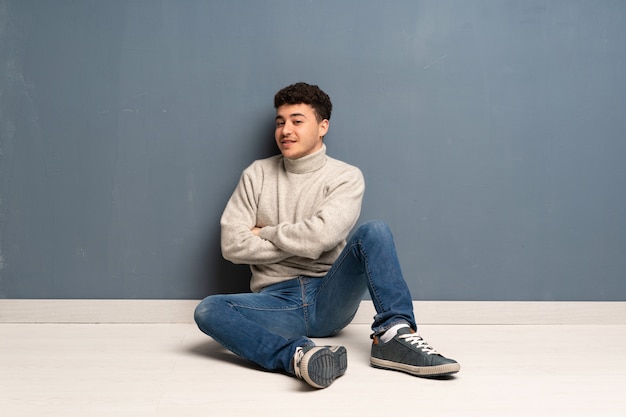 Premium Photo Young Man Sitting On The Floor With Arms Crossed And Looking Forward