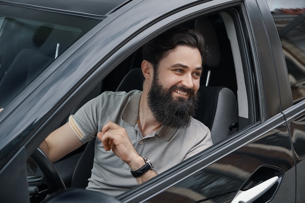 Young man smiling while driving a car Free Photo