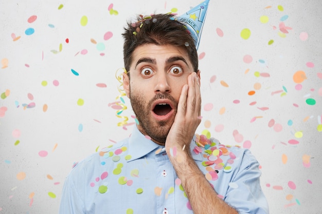 Free Photo | Young man surrounded by confetti