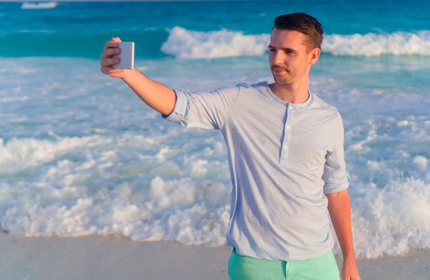 Young man  taking selfie  on the beach background the sea 