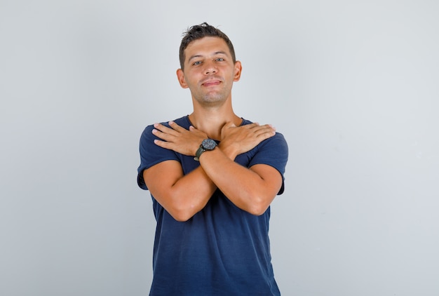 Free Photo | Young man touching shoulders with crossed hands in dark ...