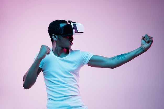 Free Photo | Young man using vr glasses in neon light