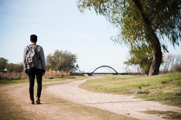 Young man walking into the park Free Photo