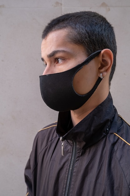 Premium Photo | Young man wearing face mask looking sideways during the ...