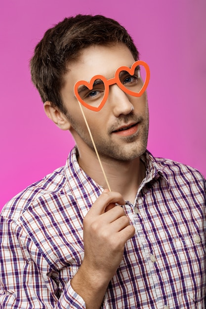 Free Photo | Young man wearing fake glasses over purple wall. birthday