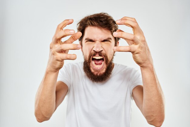 Premium Photo | A young man with a beard in a t-shirt shows different ...