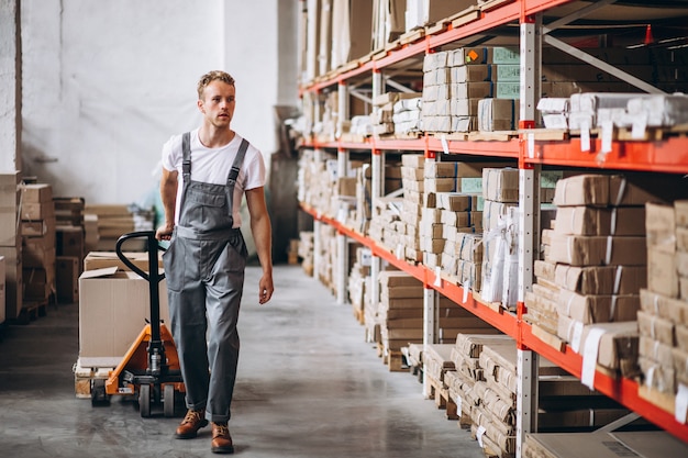 Young man working at a warehouse with boxes Free Photo