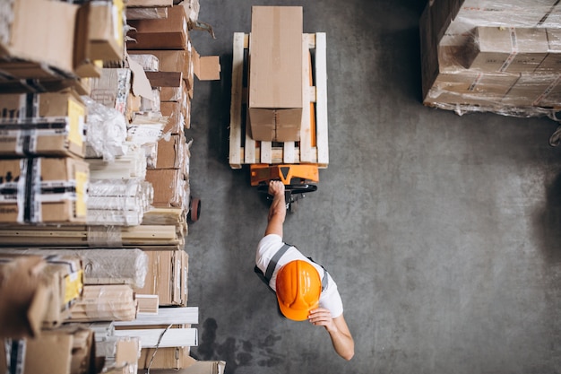 Young man working at a warehouse with boxes Free Photo