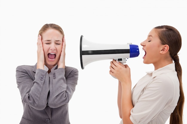 Young manager yelling at her employee through a megaphone Premium Photo