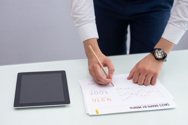 Young marketing manager writing notes on report in office Free Photo