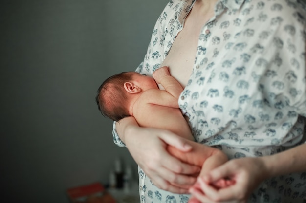 A young mother breastfeeds a baby. Premium Photo