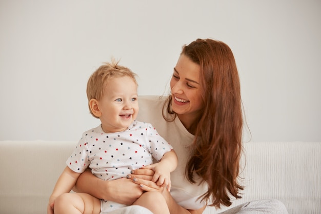 Young mother with her one years old little son dressed in pajamas are relaxing Free Photo