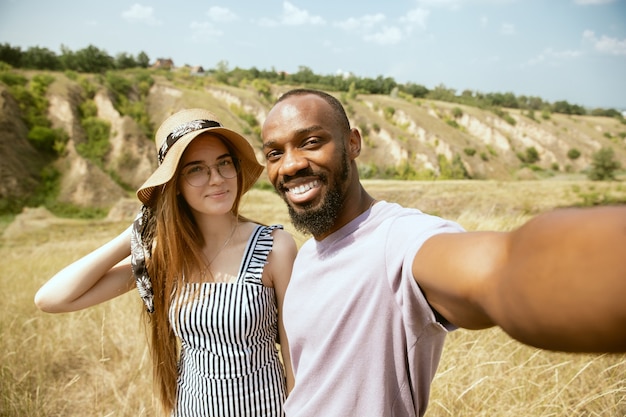 https://image.freepik.com/free-photo/young-multiethnic-international-couple-outdoors-meadow-sunny-summer-day-african-american-man-caucasian-woman-having-picnic-together-concept-relationship-summertime-making-selfie_155003-31635.jpg