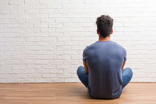 Premium Photo Young Natural Man Sit On A Wooden Floor Showing Back Posing And Waiting 8625