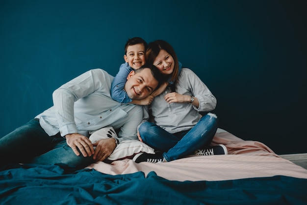 Young parents lie with their son on the bed Free Photo