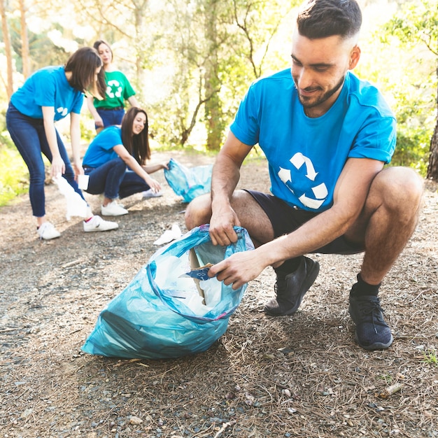 Young people picking garbage in woods Photo | Free Download