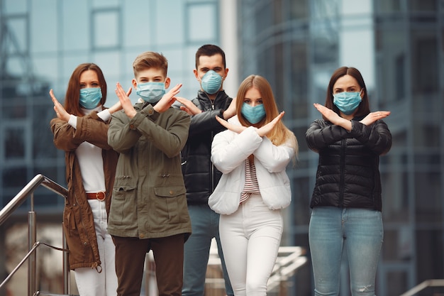 Young people wearing pespirators are crossing hands Free Photo