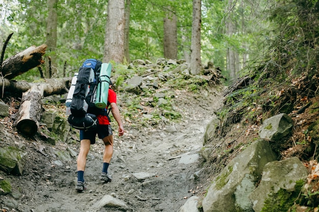 Premium Photo | Young person hiking with a backpack in the forest