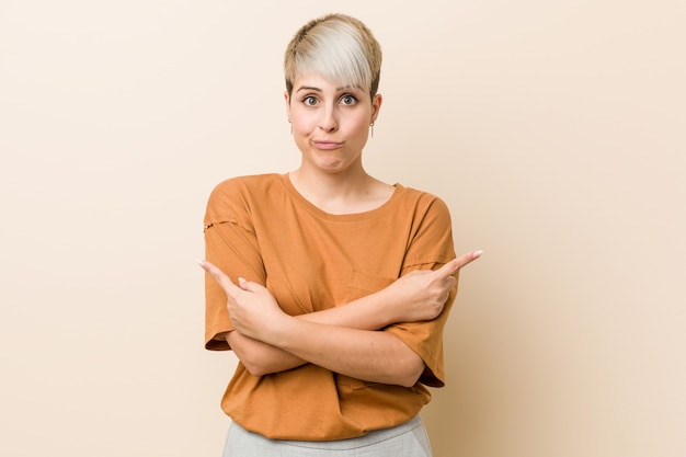 Premium Photo Young Plus Size Woman With Short Hair Points Sideways Is Trying To Choose Between Two Options