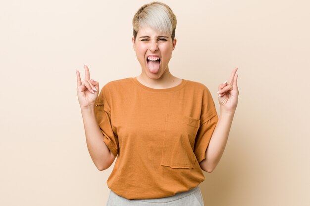 Young Plus Size Woman With Short Hair Showing Rock Gesture With