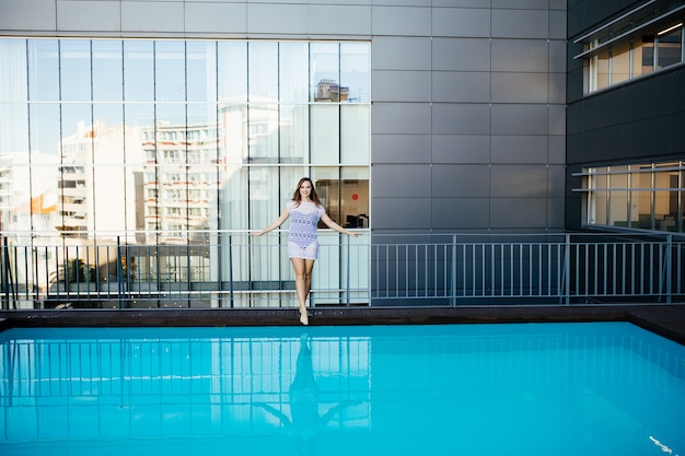 プールの上のビキニで暑い夏に屋外でポーズをとる若いかわいいファッションスポーツの女性 無料の写真